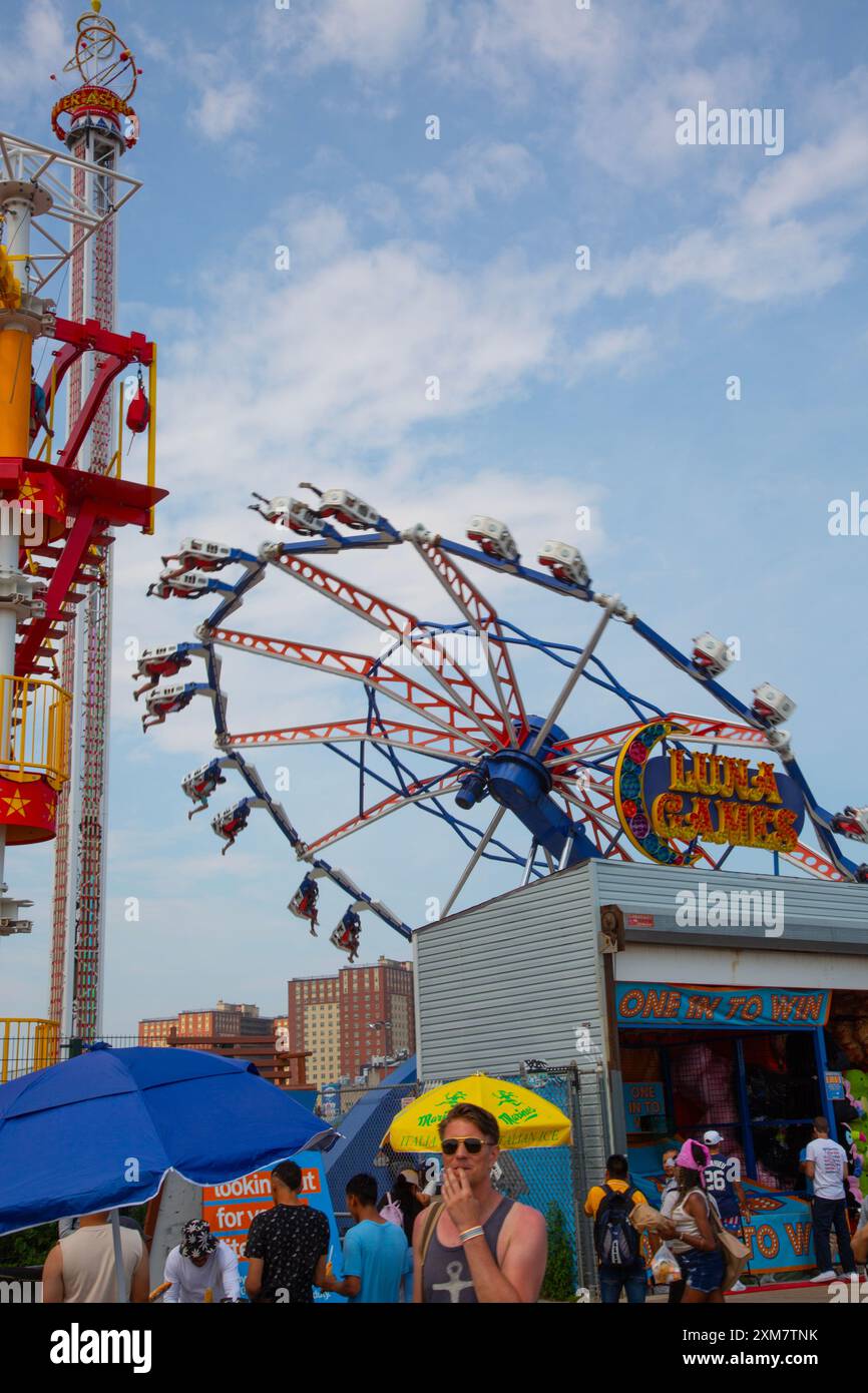 People on the rides at the amusement park off the boardwalk at Coney ...