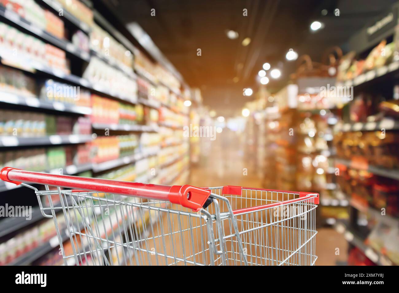 supermarket aisle blurred background with empty red shopping cart Stock ...