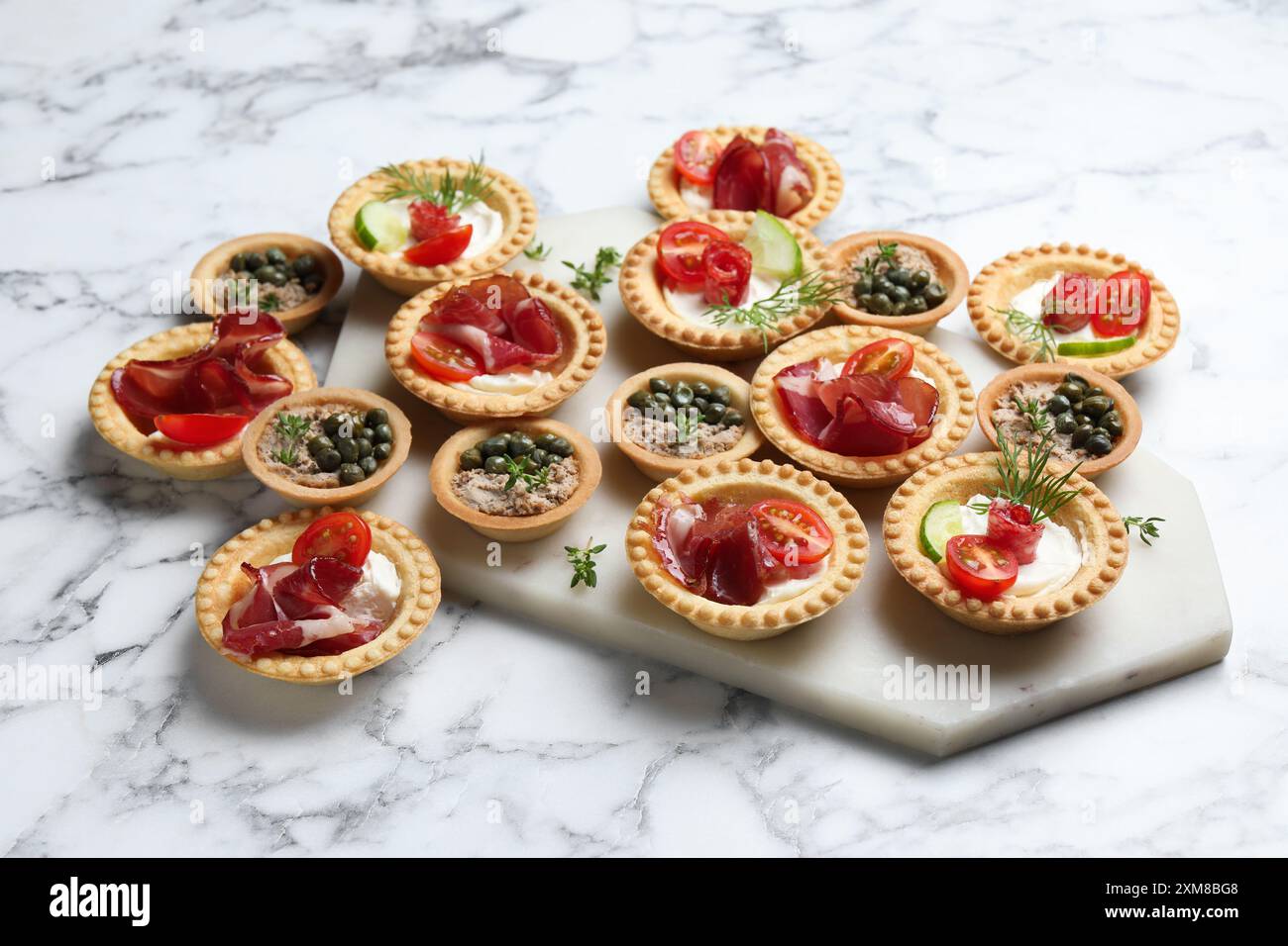 Different delicious canapes on white marble table Stock Photo - Alamy