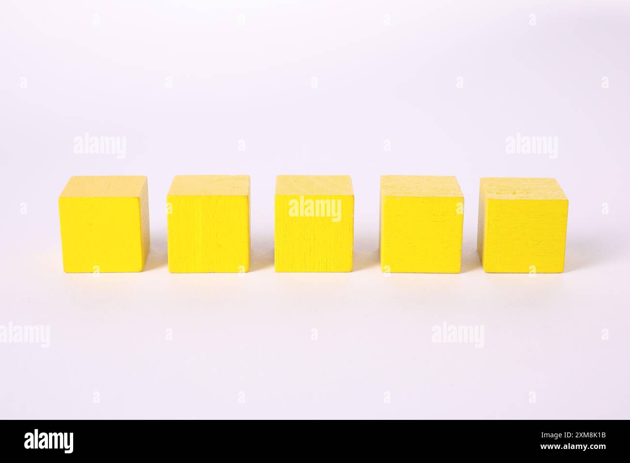 Many yellow wooden cubes isolated on white Stock Photo - Alamy