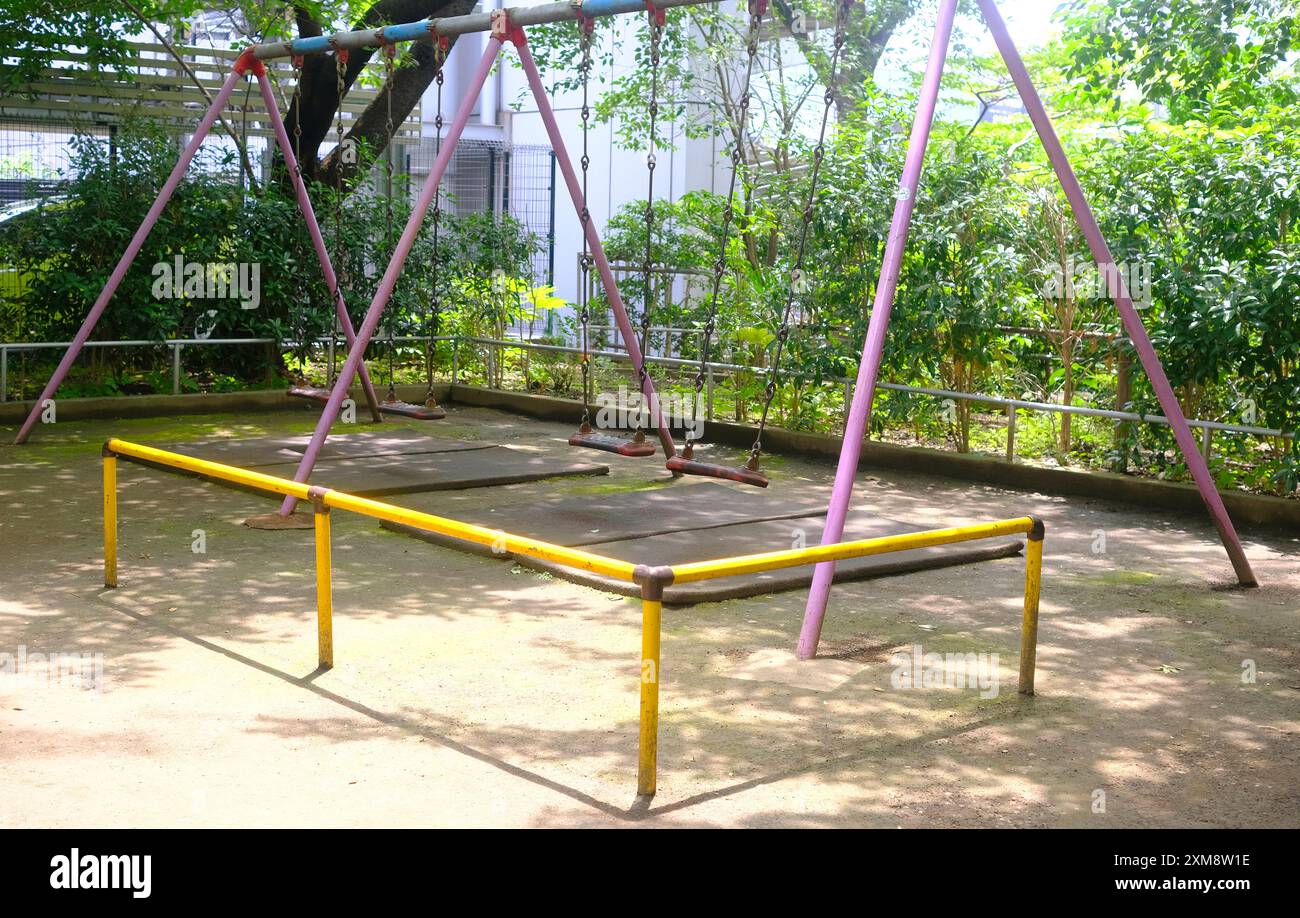 The pink joyful swing for child and kids in Japan playground Stock Photo