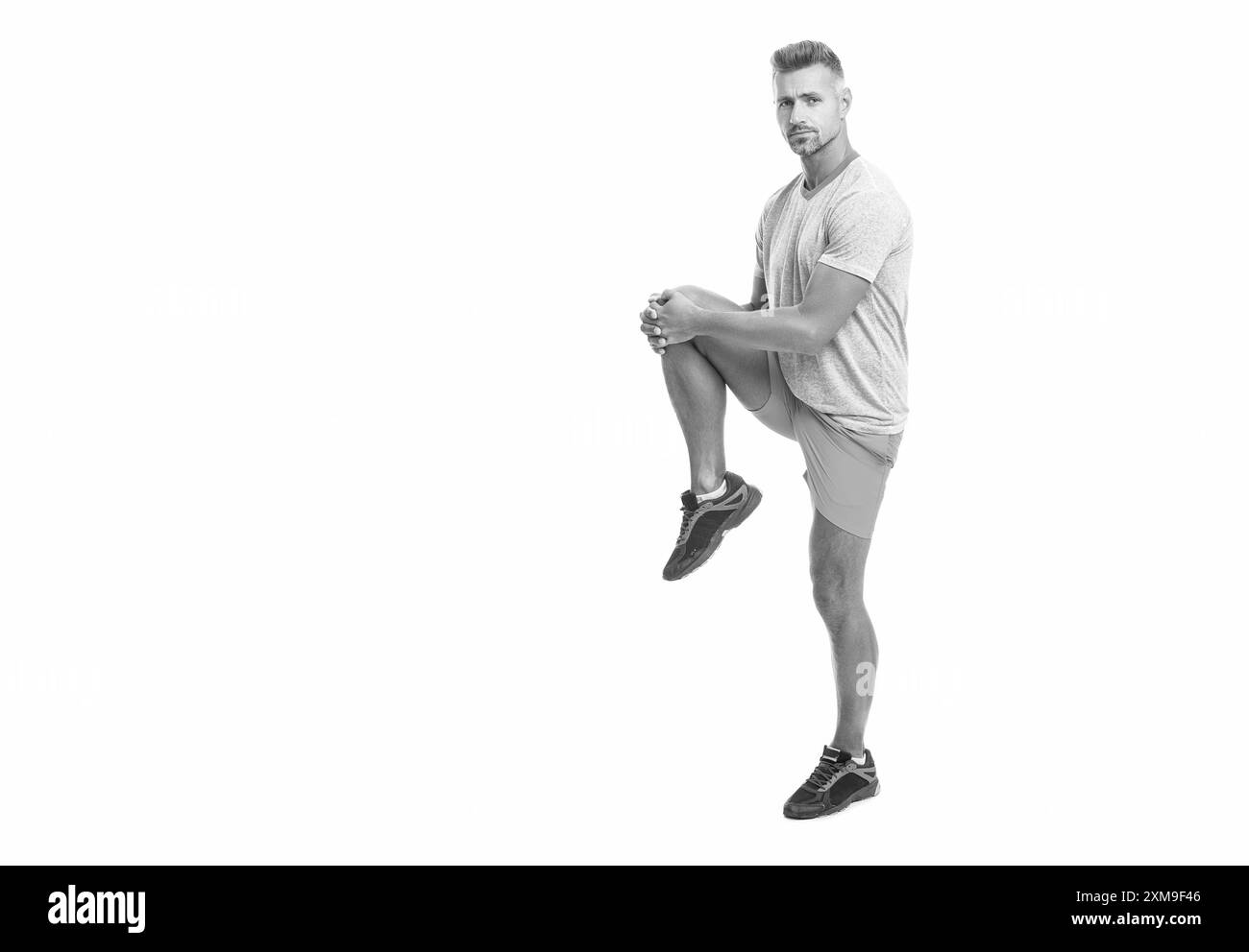 man runner warming up and stretching muscle before workout isolated on white background, copy space Stock Photo