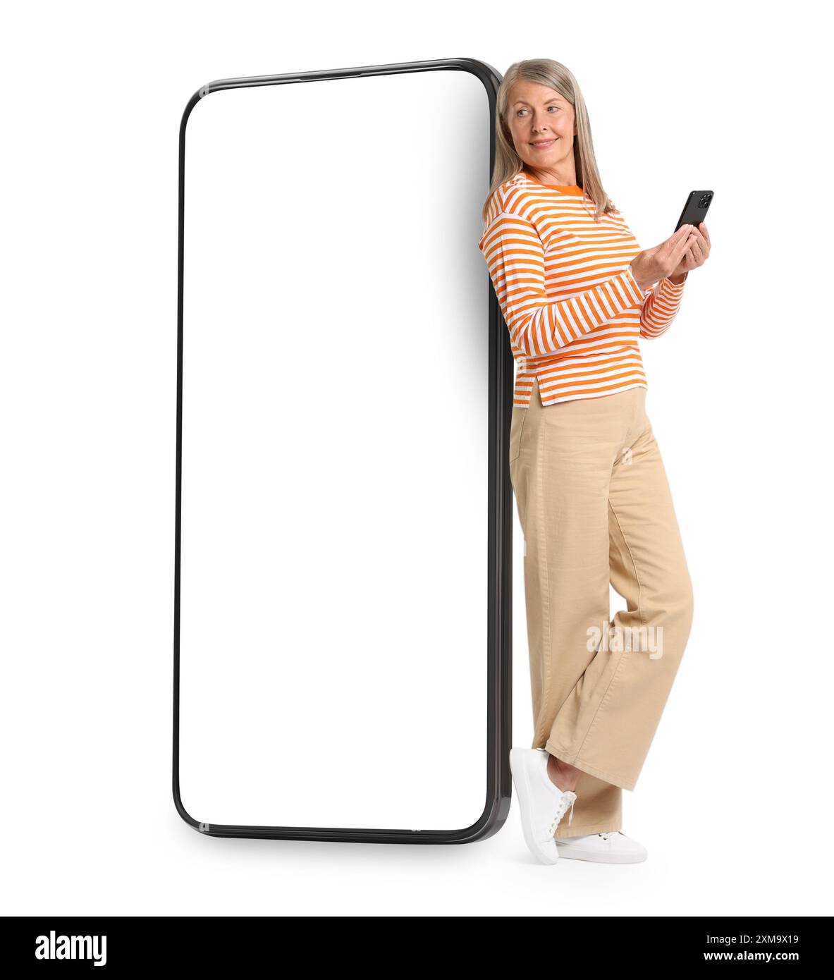 Happy mature woman holding mobile phone near big smartphone on white background Stock Photo