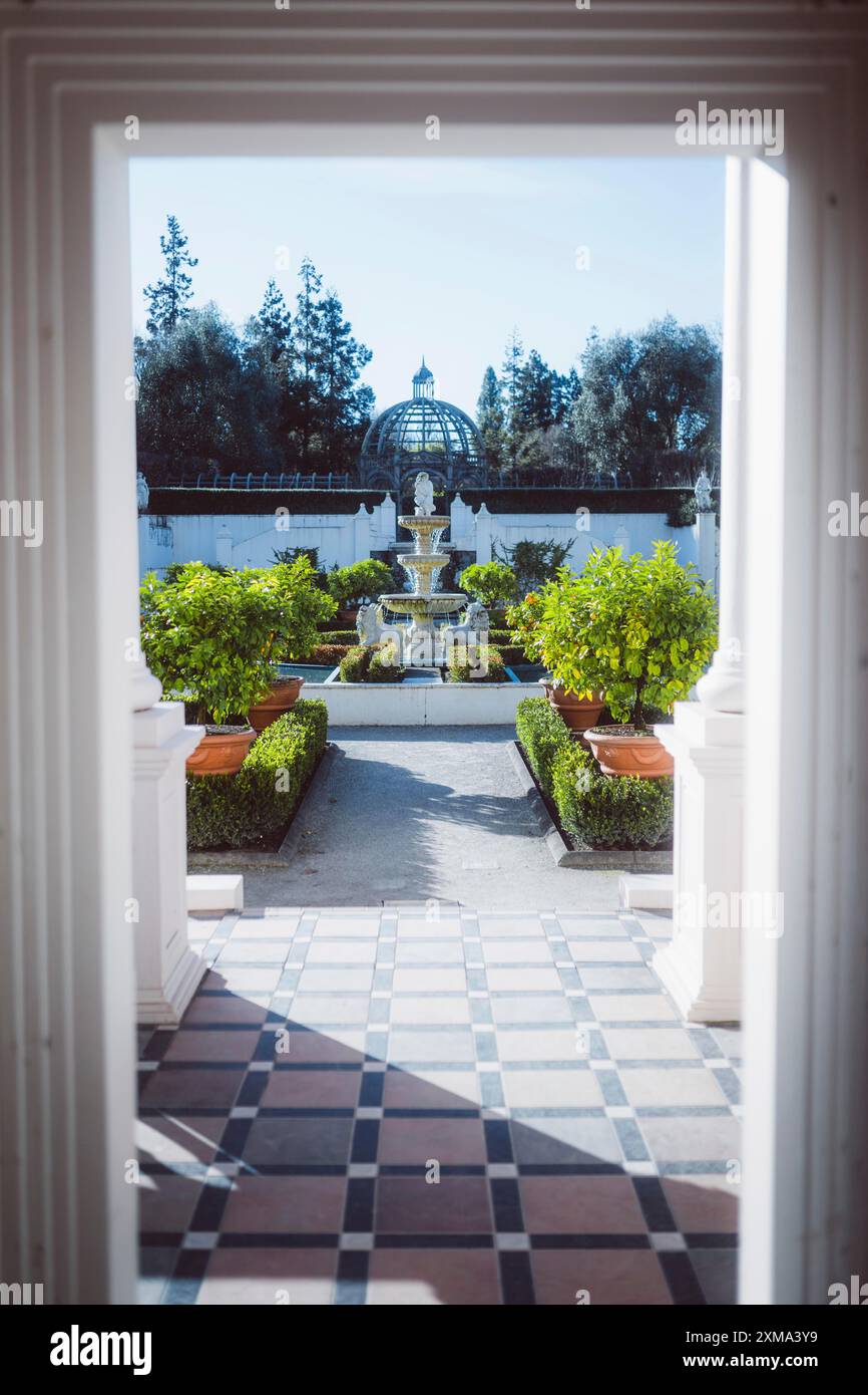 A view through a Tor tor of a symmetrical garden with a fountain and surrounded by green vegetation, Hamilton, New Zealand Stock Photo