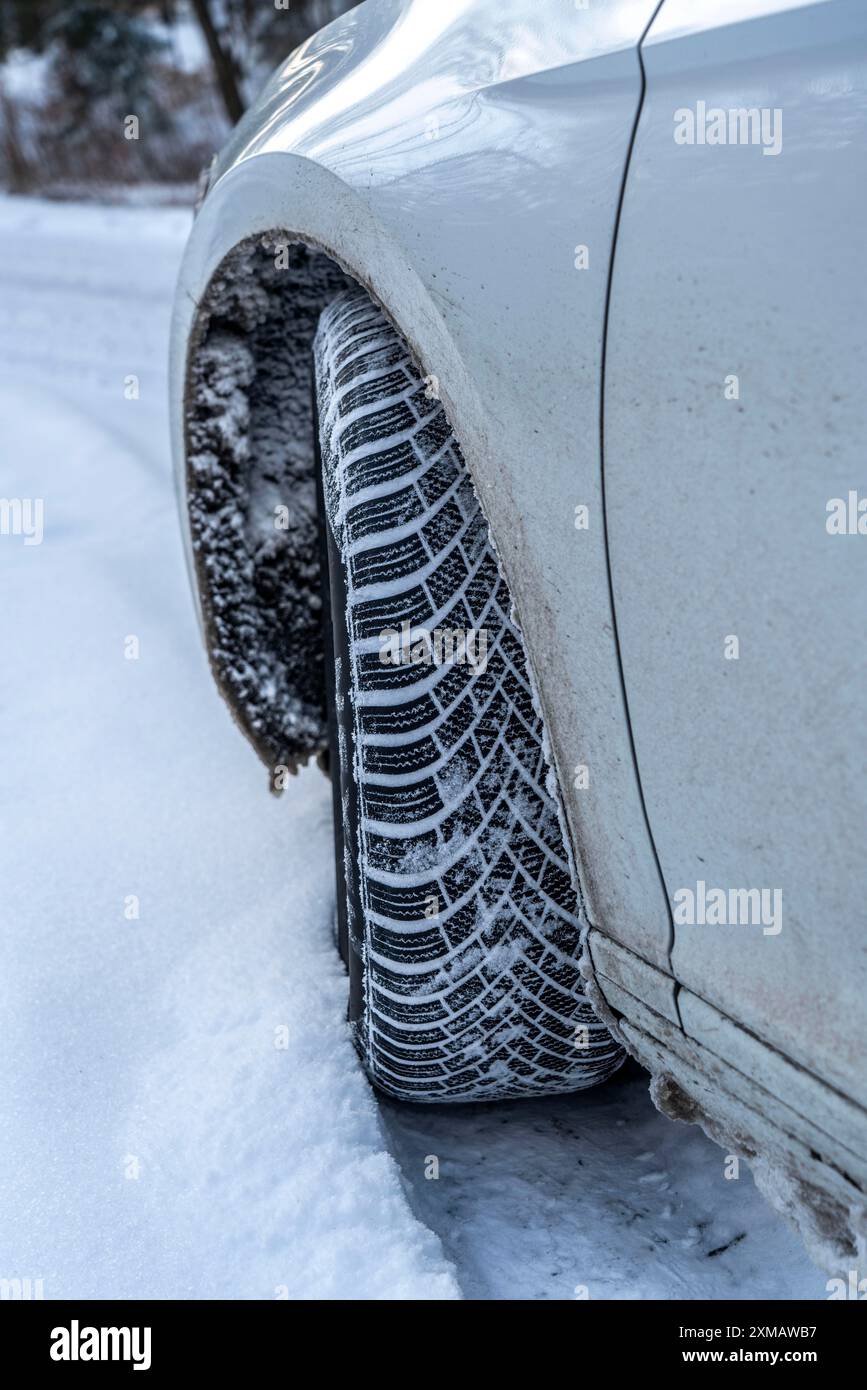 Winter tyres, driving on a road with snow cover, grip on the snow thanks to the special tread and rubber compound, the tyre for winter Stock Photo