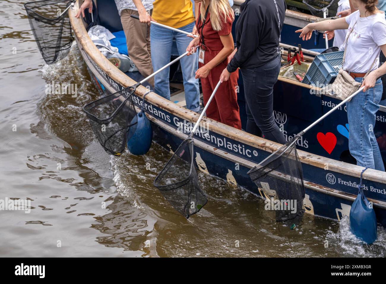 Plastic Whale boat in a canal in Amsterdam, passengers fish plastic waste out of the canals, tour through the canals of Amsterdam, collecting waste Stock Photo