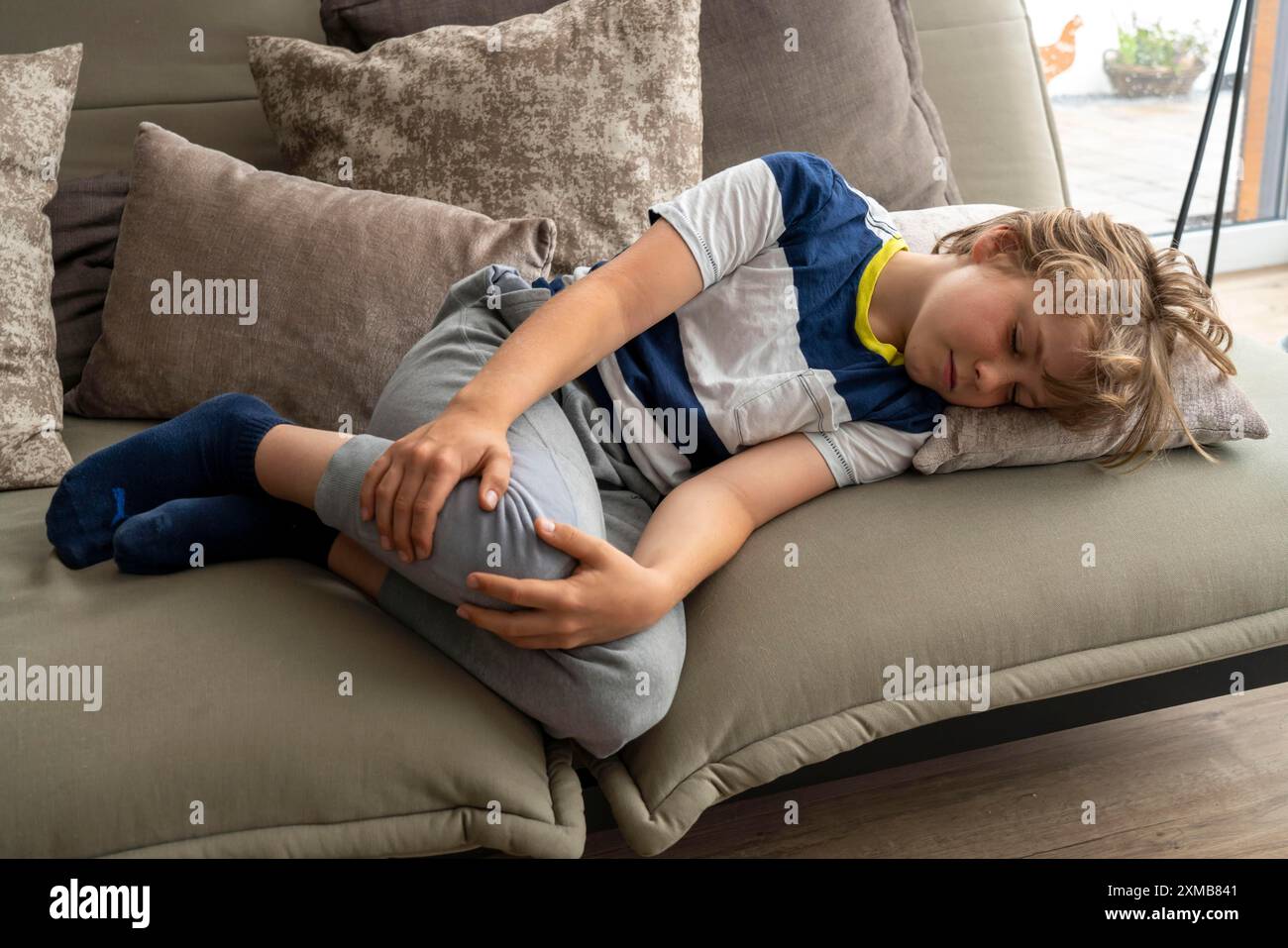 Growing pains in children, boy, 10 years old, has pain in his leg, symbolic picture Stock Photo