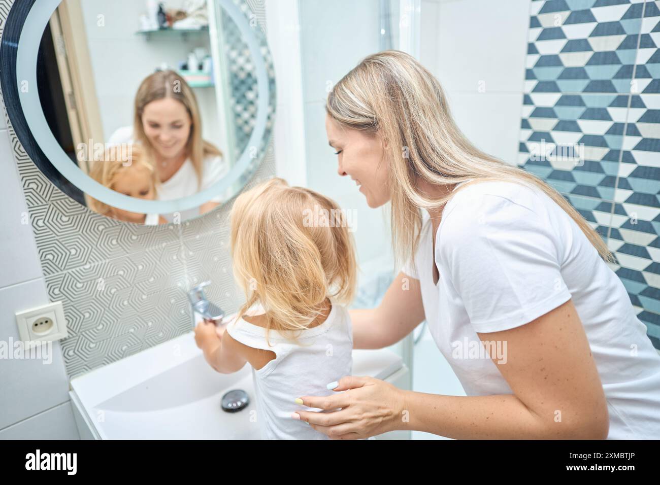 Mom teaches her child hands washing with soap in bathroom Stock Photo ...