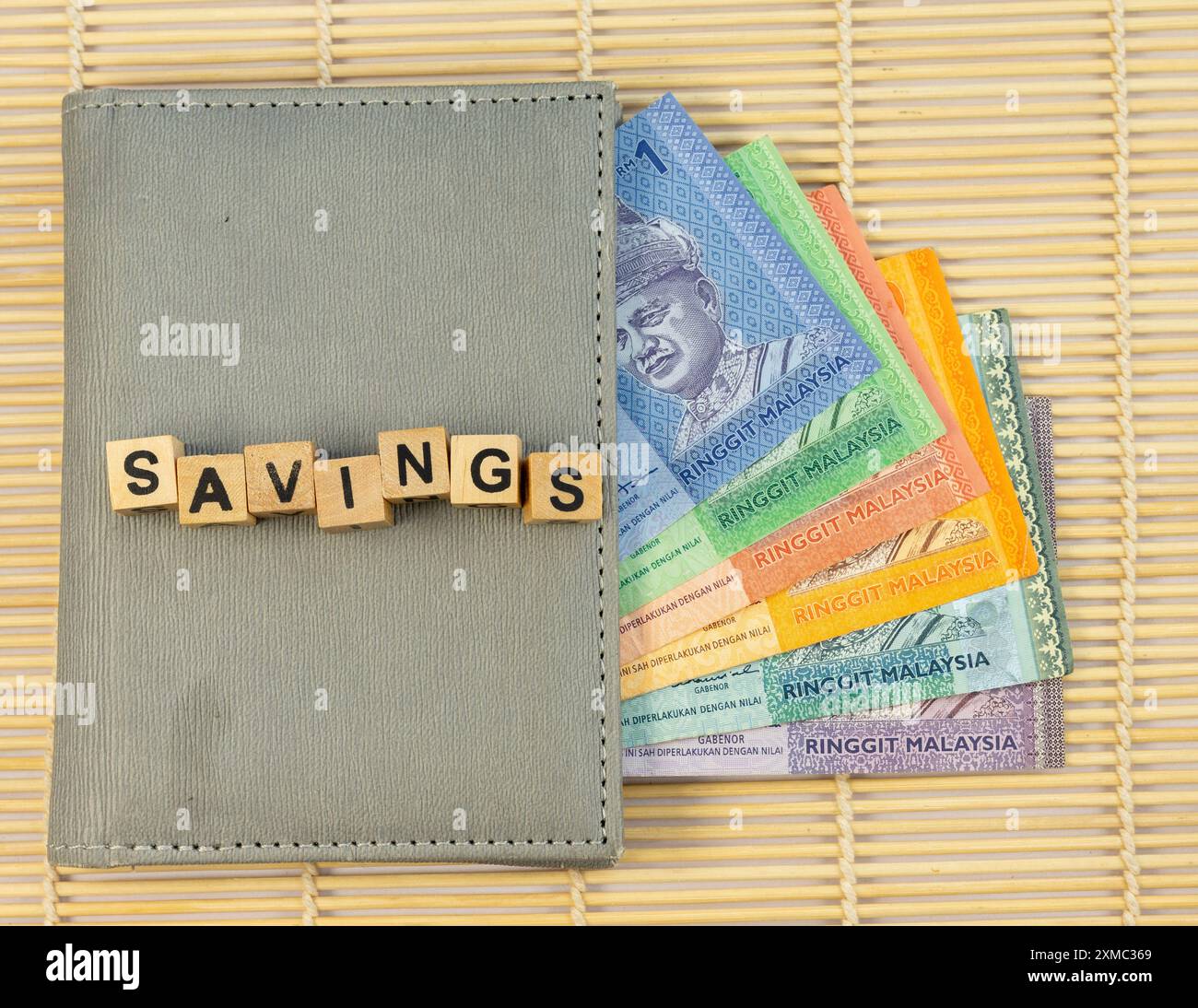 SAVINGS text on a wooden blocks cubes on a wallet full with Malaysian Ringgit banknotes Stock Photo