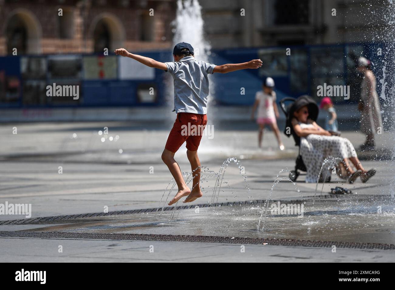 Torino, Italia. 27th July, 2024. Un ragazzo cerca refrigerio in una fontana durante il primo picco di caldo estivo a Torino, Italia - Cronaca - sabato 27 luglio 2024 - ( Photo Alberto Gandolfo/LaPresse ) A boy seeks refreshment in a fountain during the first peak of summer heat in Turin, Italy - Saturday, July 27, 2024 - News - ( Photo Alberto Gandolfo/LaPresse ) Credit: LaPresse/Alamy Live News Stock Photo