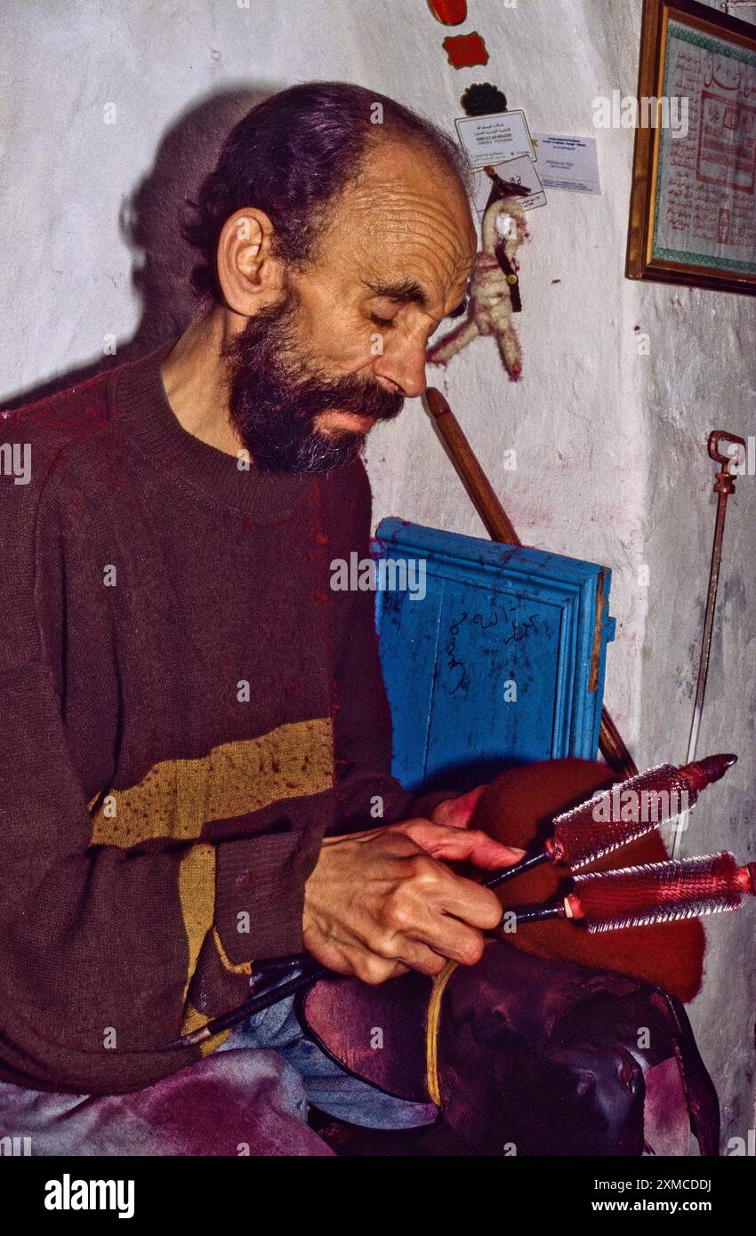 Tunisian Hat, Chechia.  Yusuf bin Ali, Brushing a Chechia with Metal Thistle-combs. Stock Photo