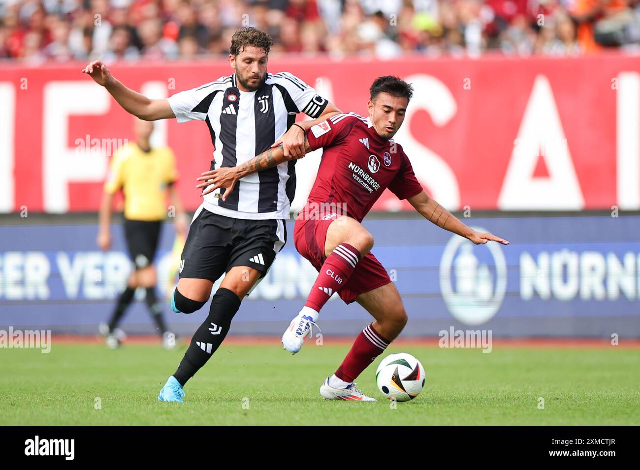 Nuremberg, Germany. 26th July, 2024. Soccer: Test match, 1. FC Nuremberg - Juventus Turin at the Max Morlock Stadium. Nuremberg's Jens Castrop (r) fights for the ball with Juventus' Manuel Locatelli. Credit: Daniel Karmann/dpa/Alamy Live News Stock Photo