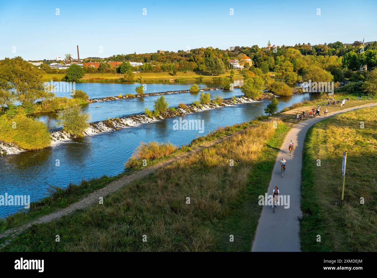 The Ruhr weir, barrage of the Ruhr near Hattingen, cyclist, on the Ruhr Valley cycle path, behind the LWL Industrial Museum Henrichshuette, North Stock Photo