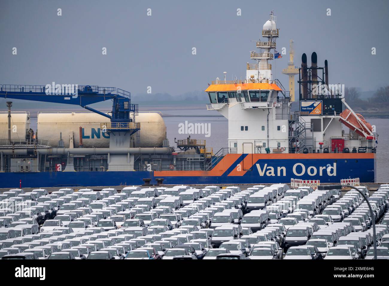 Parking space for import vehicles, hundreds of Hyundai Ioniq, electric cars, waiting for onward transport, behind them, on the Weser, the dredger Stock Photo