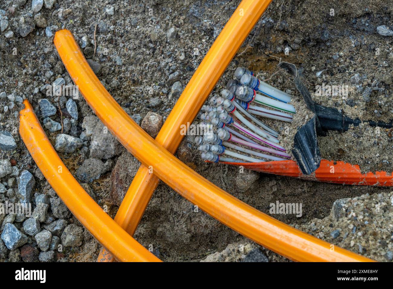 Laying of fibre optic cables, empty conduits are laid under a pavement, in which the actual fibre optic cable is later blown in and connected to the Stock Photo