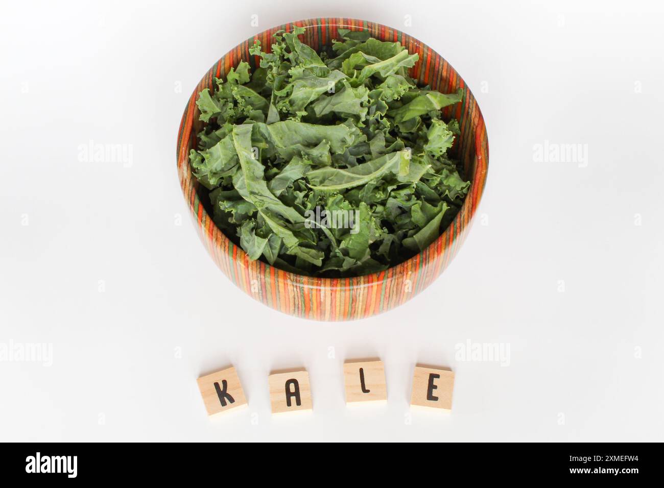 Kale Lette Chopped kale in colorful bowl with letter tiles on white background ...