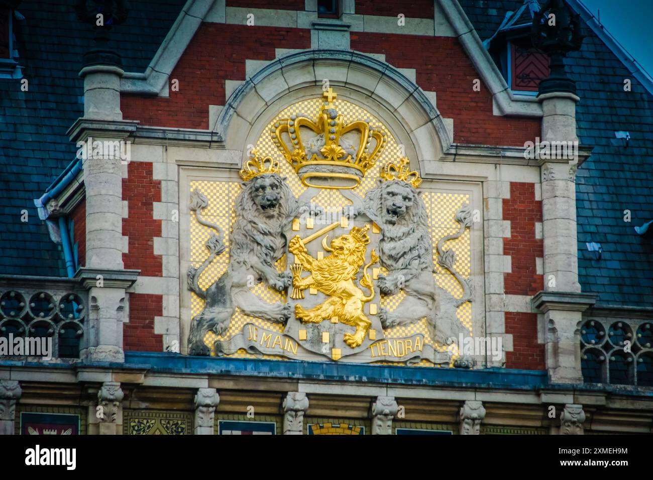 The Amsterdam Centraal Station features the coat of arms of the Netherlands. A crowned lion stands proudly, holding a sword and seven arrows. This sym Stock Photo