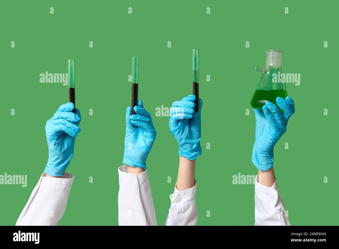 Scientist's hands holding test tubes with soil and green liquid on ...