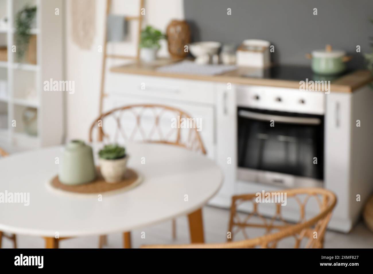 Blurred view of light kitchen with counters and dining table Stock ...