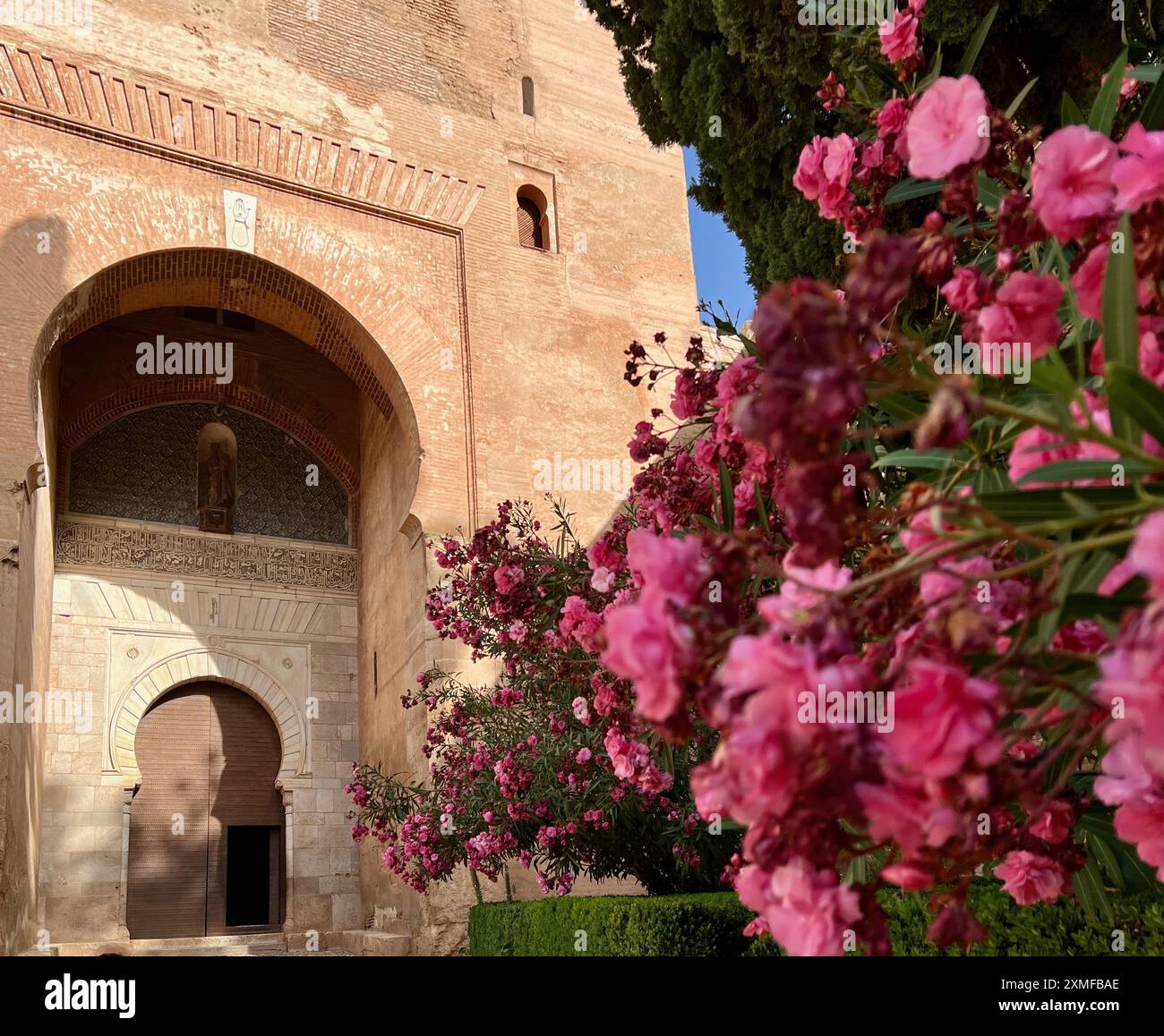 Flowers bloom outside the Gate of Justice at the Alhambra in Granada, Spain. Stock Photo