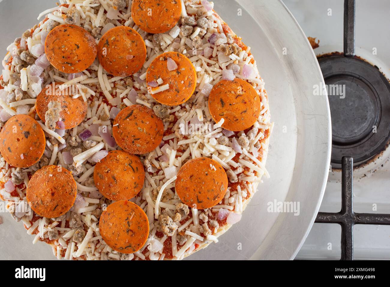 A top down view of a dairy-free and gluten-free frozen pizza, resting on a stove top. Stock Photo