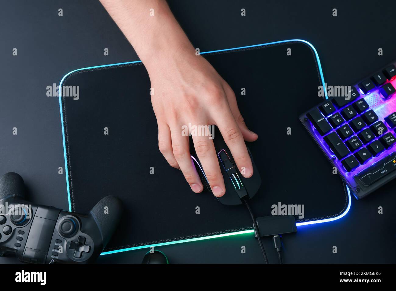 Gamer using modern wired computer mouse at black table, top view Stock Photo