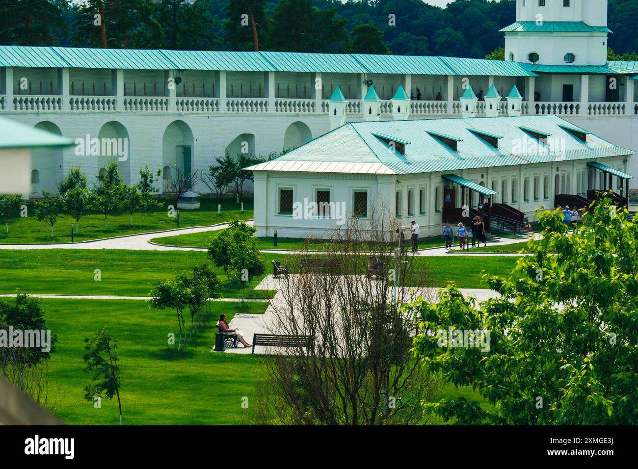 A white building complex featuring green roofs in the monastery, arched ...
