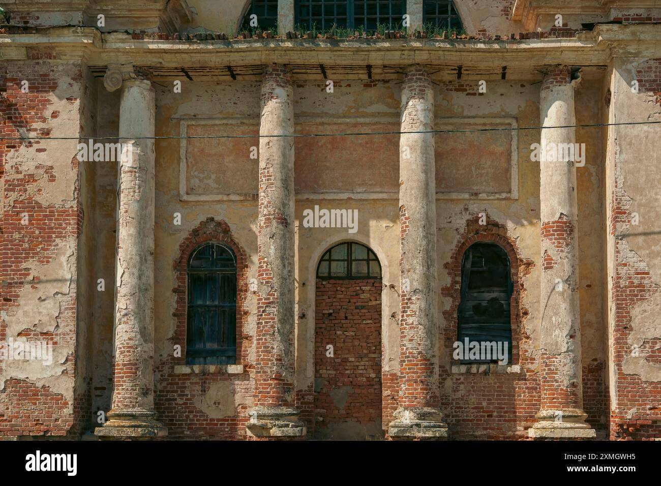 Facade of an abandoned church featuring weathered columns and ...