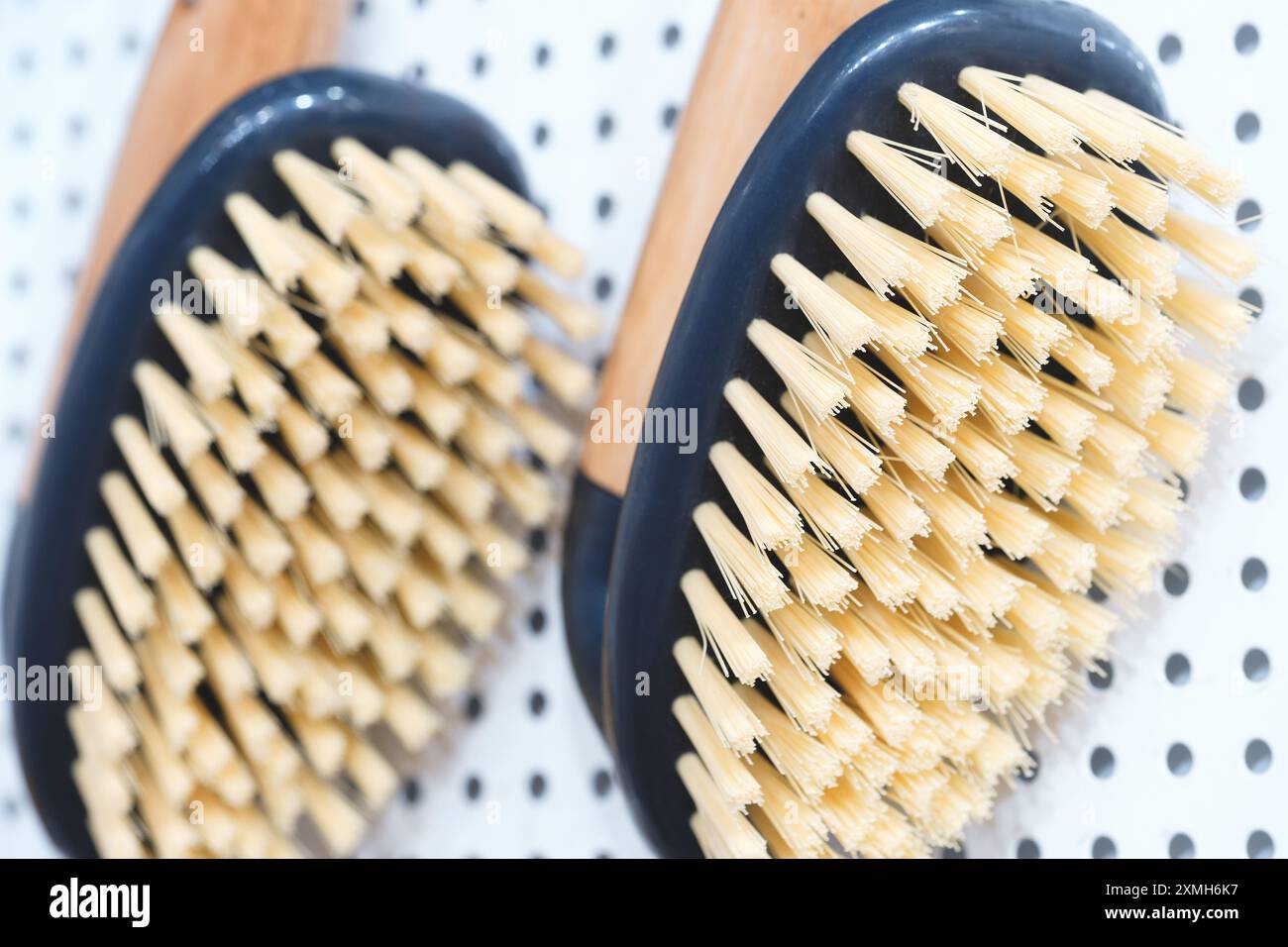 Two brushes with white bristles and black handles. One is on the left ...