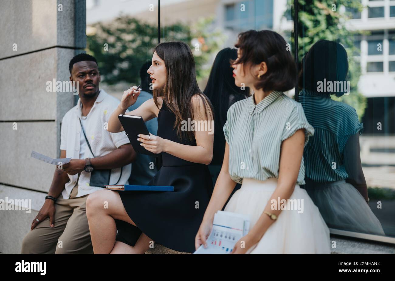 Diverse group of young professionals having an outdoor business meeting ...