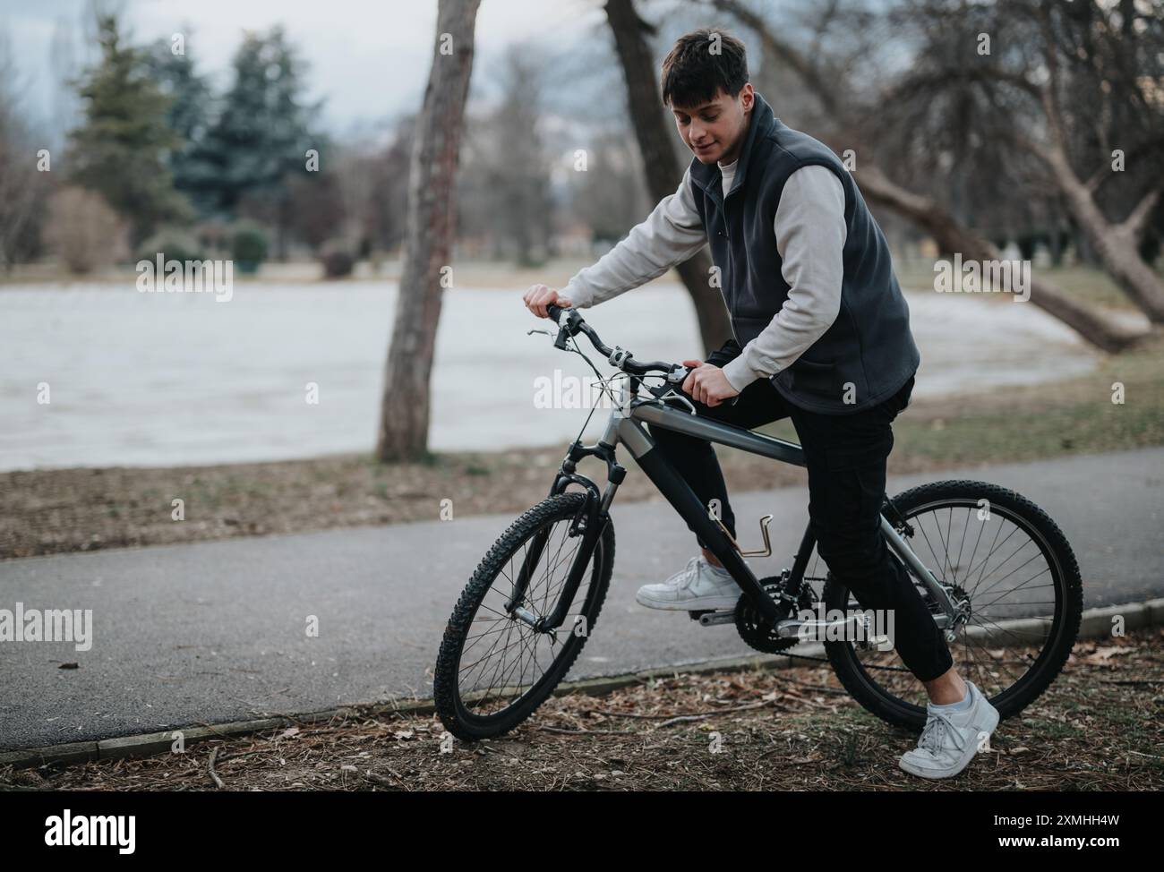 Teenage boy enjoying a leisurely bike ride in the park Stock Photo - Alamy