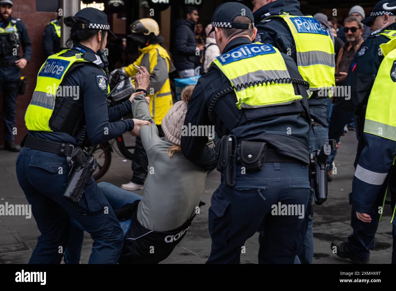 A protester is dragged away as she is arrested after she refused to listen to the police orders during the demonstration. The Melbourne wet weather could not stop week 42 of the weekly free Palestine rallies in Melbourne. This week there was a higher police presence with even a passer by who has now become a weekly member of the protest, she is being arrested after she refused to listen to police orders. Stock Photo