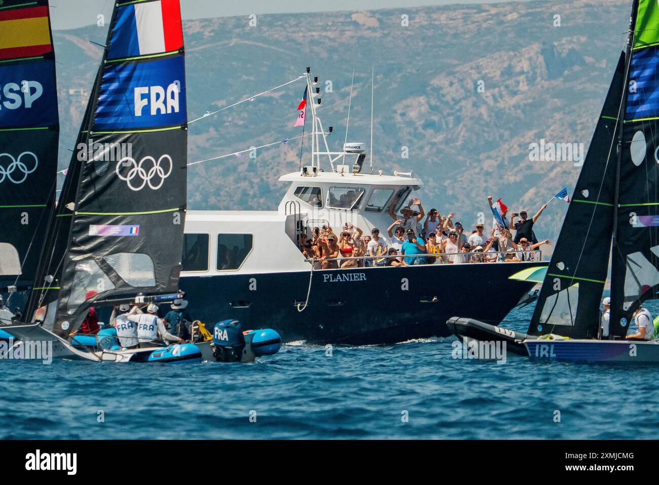 Olympic fans on a party boat wave French flags and cheer while passing ...