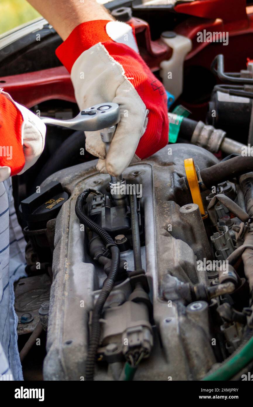 Disassembling of a car ignition system with a ratchet wrench Stock Photo