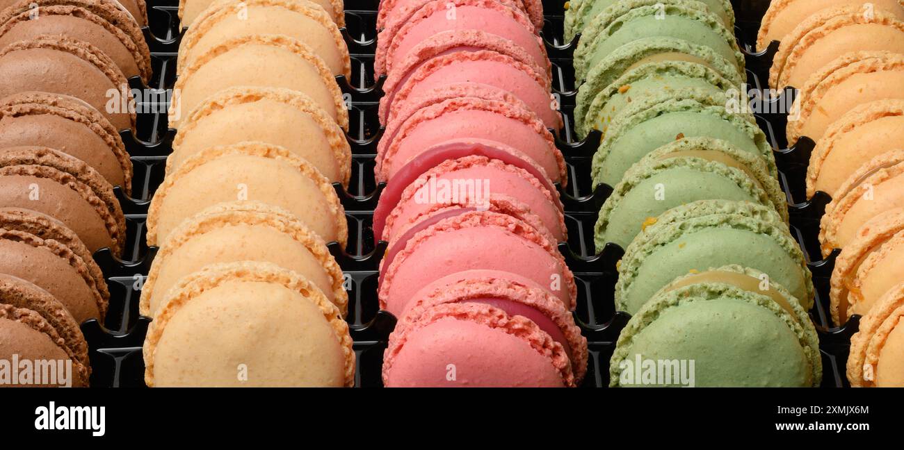 Multi-colored macarons in a plastic box, top view. Assortment Stock Photo