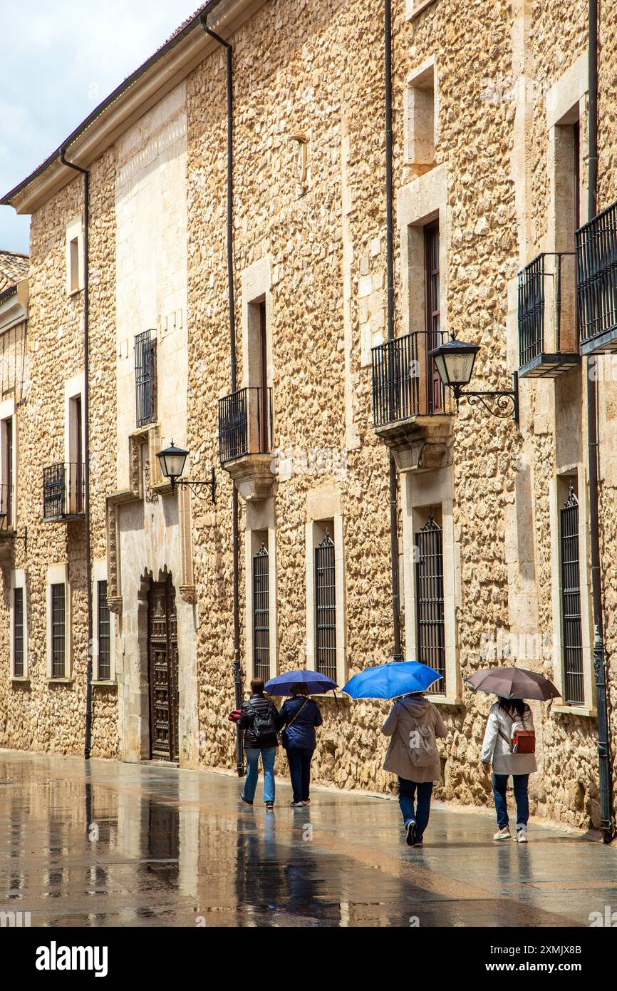 People walking in the rain and wet weather in the Spanish medieval walled city of El Burgo de Osma in the Province of soria Castile and Leon Spain Stock Photo