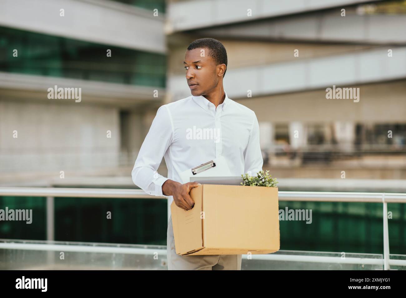 African American Man Carrying Box Leaving Workplace Stock Photo