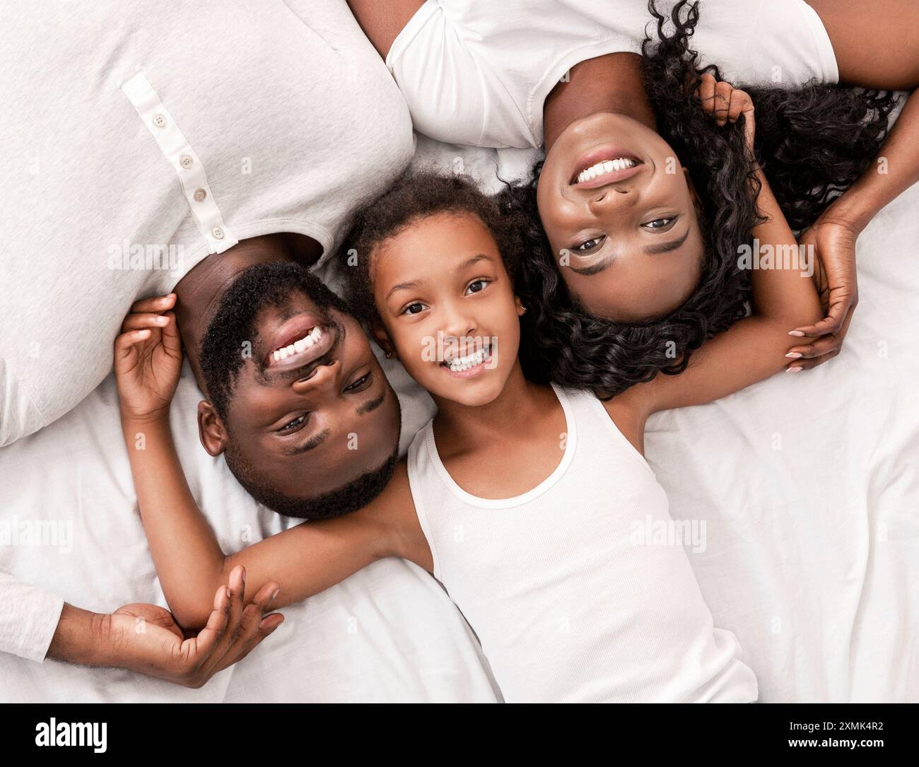 Top view of happy black family lying in bed together Stock Photo - Alamy