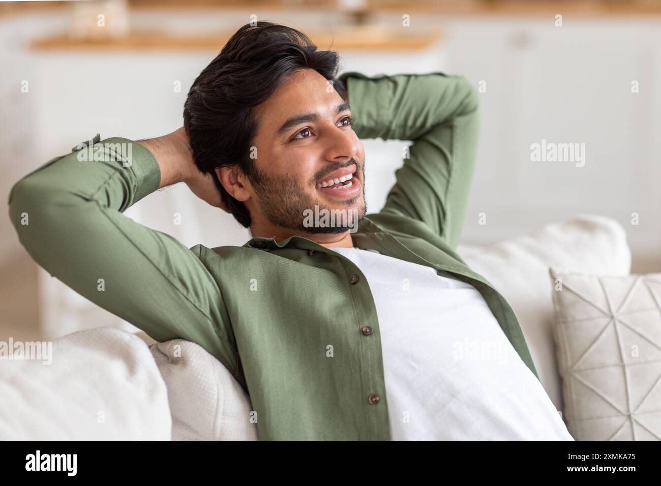 Relaxed Man Leaning Back on a Couch at Home Stock Photo