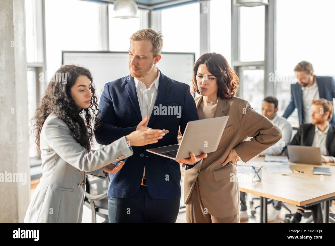 Business Professionals Collaborating on Laptop in Modern Office Stock Photo