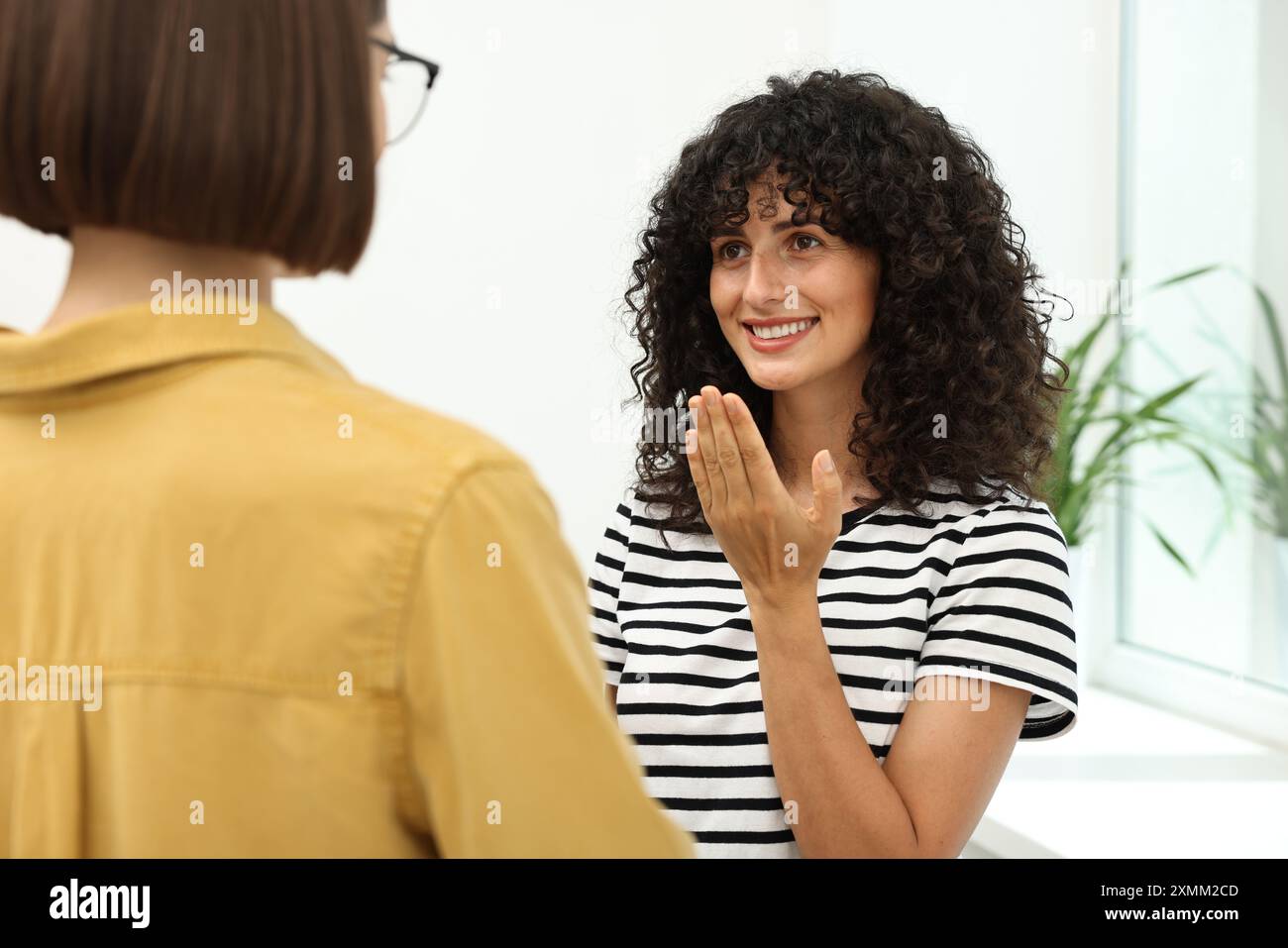 Young women using sign language for communication indoors Stock Photo