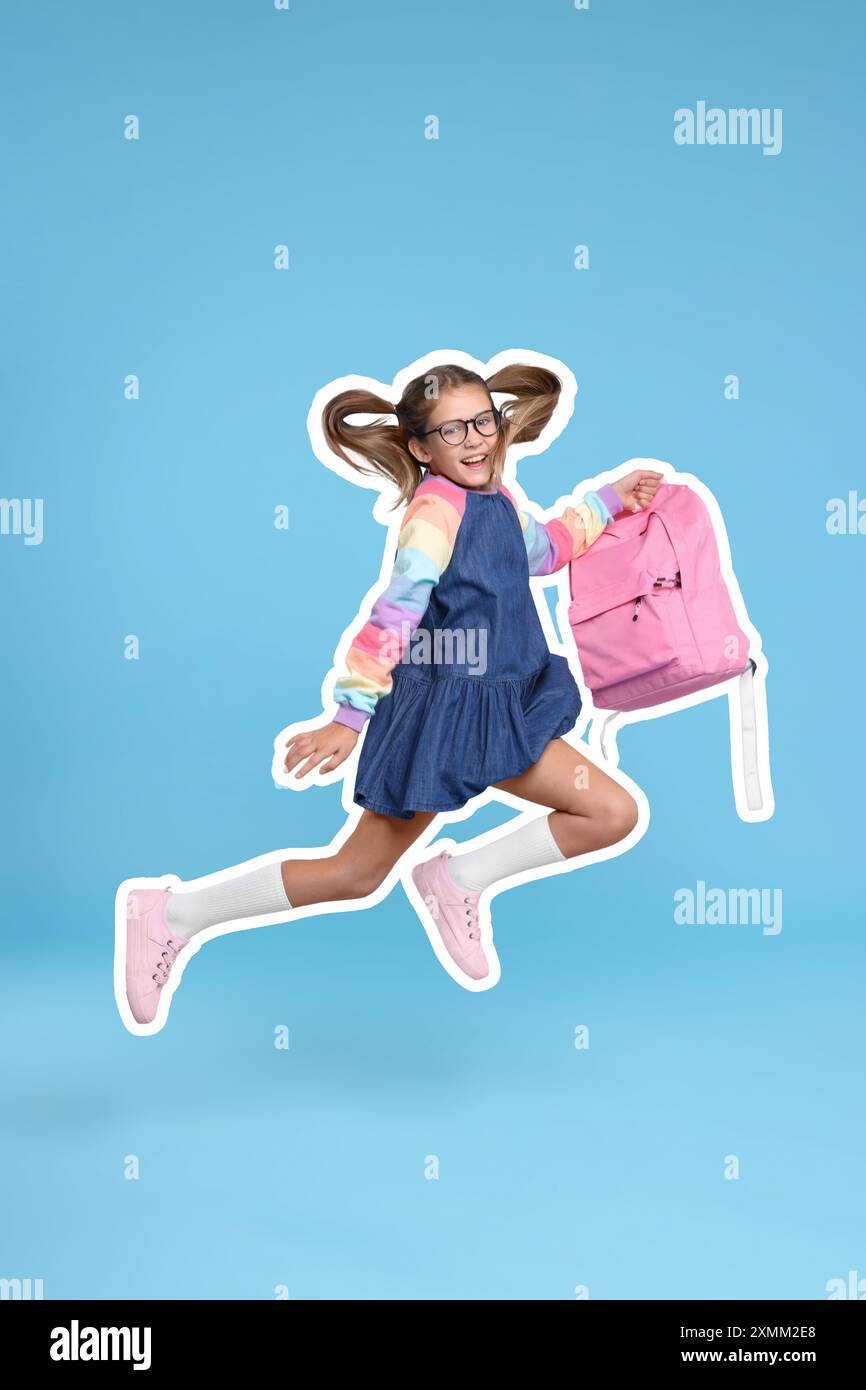 Happy school child with backpack jumping on light blue background Stock ...