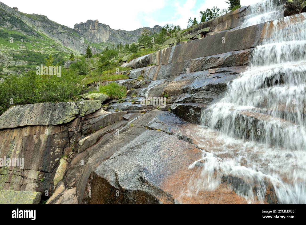 Round Step Waterfall A rushing stream of water flows down the stone steps of a natural ...