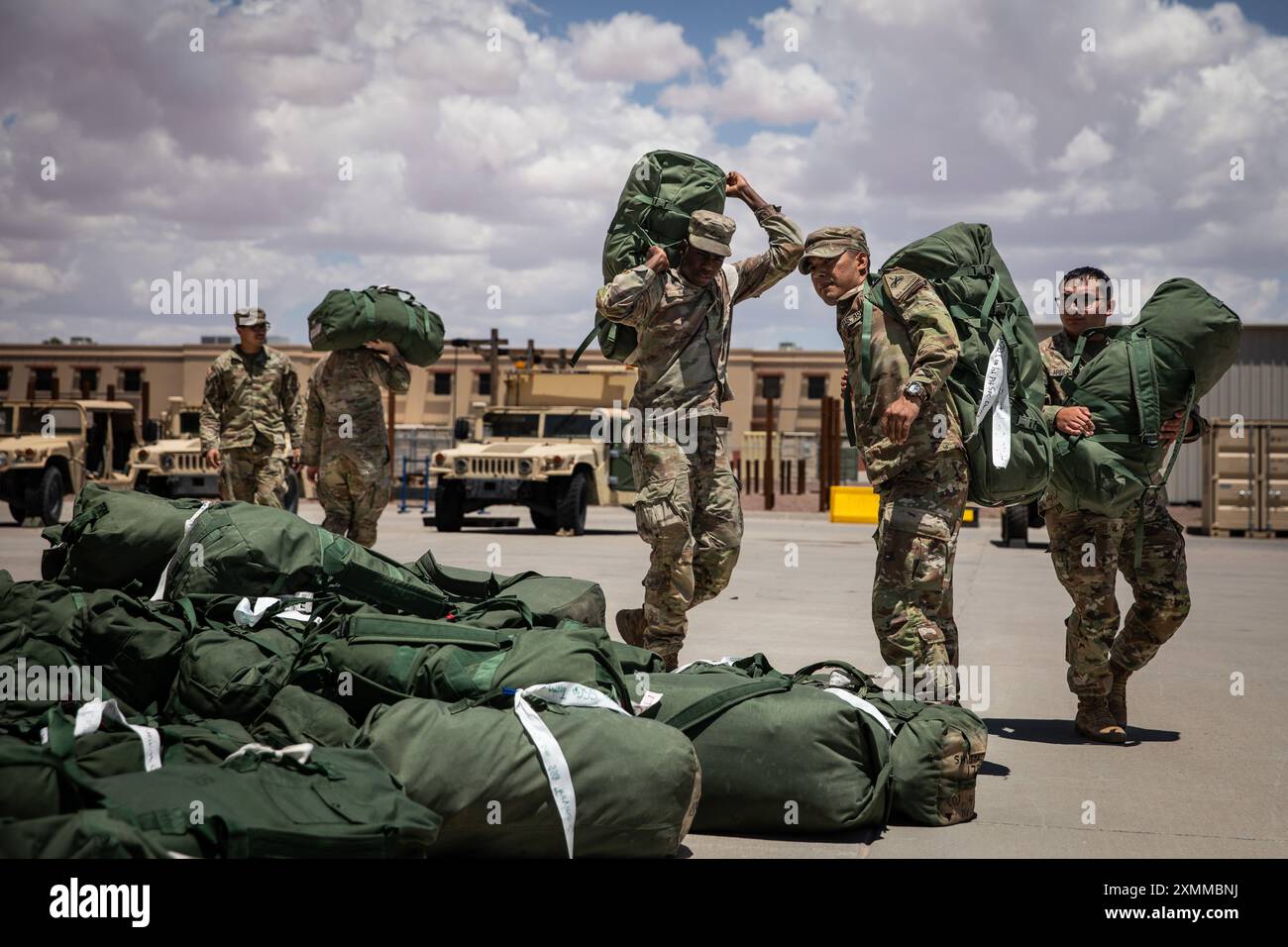 U.S. Army Soldiers assigned to Charlie Company, 4th Battalion, 70th Armored Regiment, 1st Armored Brigade Combat Team, 1st Armored Division, prepare to load a group of duffle bags into a conex in support of a deployment readiness exercise at Fort Bliss, Texas, July 19, 2024. The deployment readiness exercise is in support of Operation Pacific Fortitude, which supports long-standing agreements to the Republic of Korea by deploying forces, drawing and transporting equipment to validate unit readiness and the U.S. commitment to the alliance. (U.S. Army photo by Sgt. Eric Kestner) Stock Photo