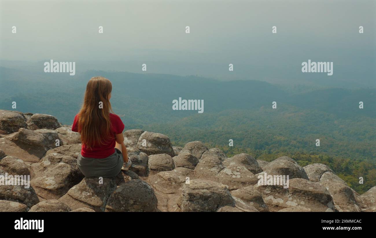 Woman sitting on edge cliff hi-res stock photography and images - Alamy