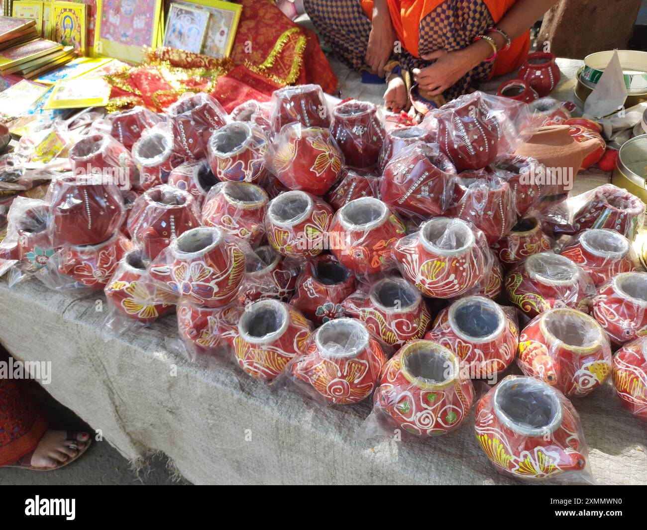 21 October 2021 Dewas, Madhya Pradesh, India. An Indian woman selling earthen pots and sieves on the roadside in a street vendor market Stock Photo