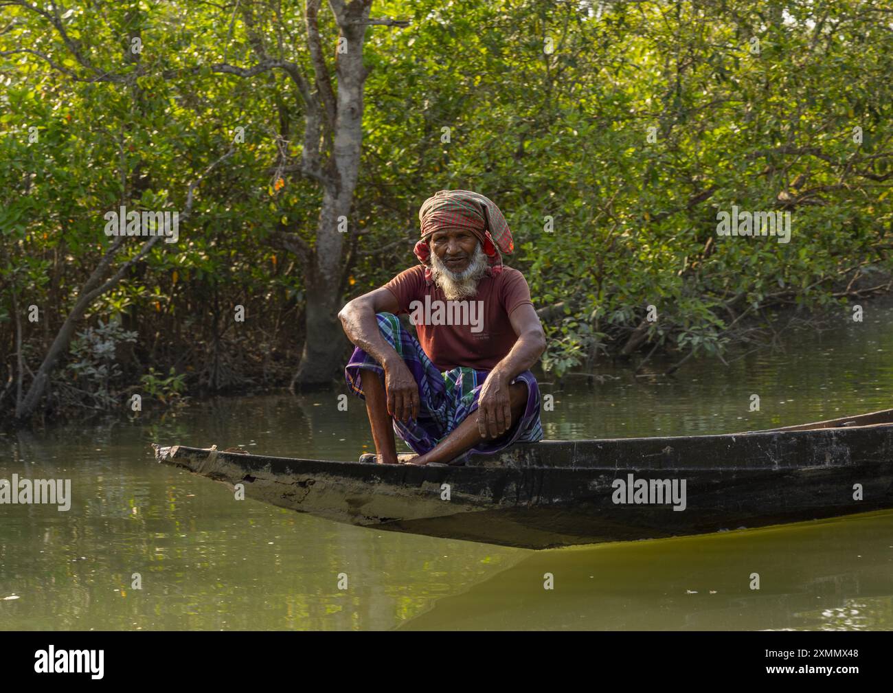 Shyamnagar Bangladeshi man in a canoe in the Sundarbans mangrove, Khulna Division ...