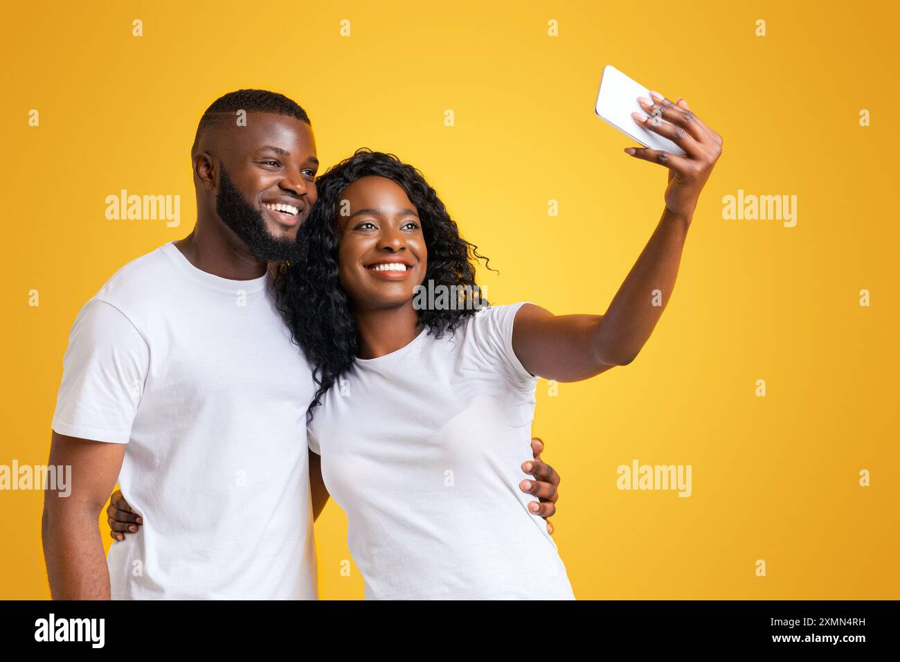 Couple Taking Selfie on Yellow Background Stock Photo