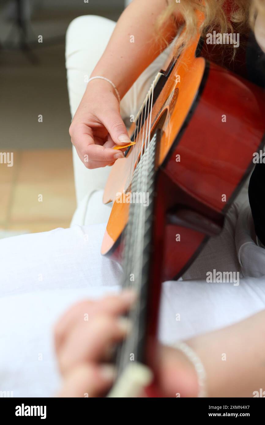 Teenage girl plays acoustic guitar using guitar pick Stock Photo - Alamy