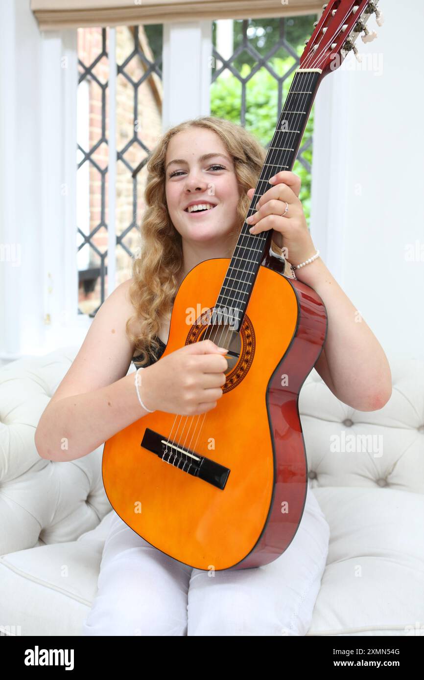 Teenage girl plays acoustic guitar Stock Photo - Alamy